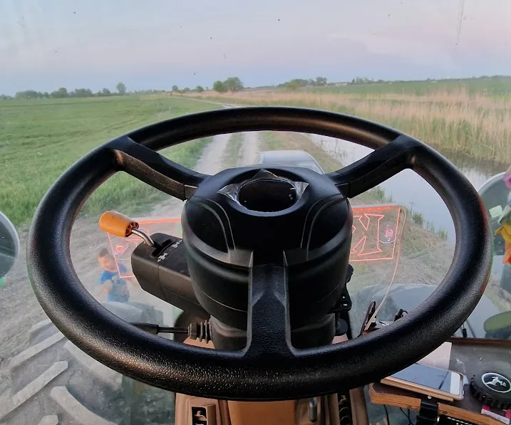 Traktorfülkébe szerelt agymotoros kormányforgató, kilátással a táblára
